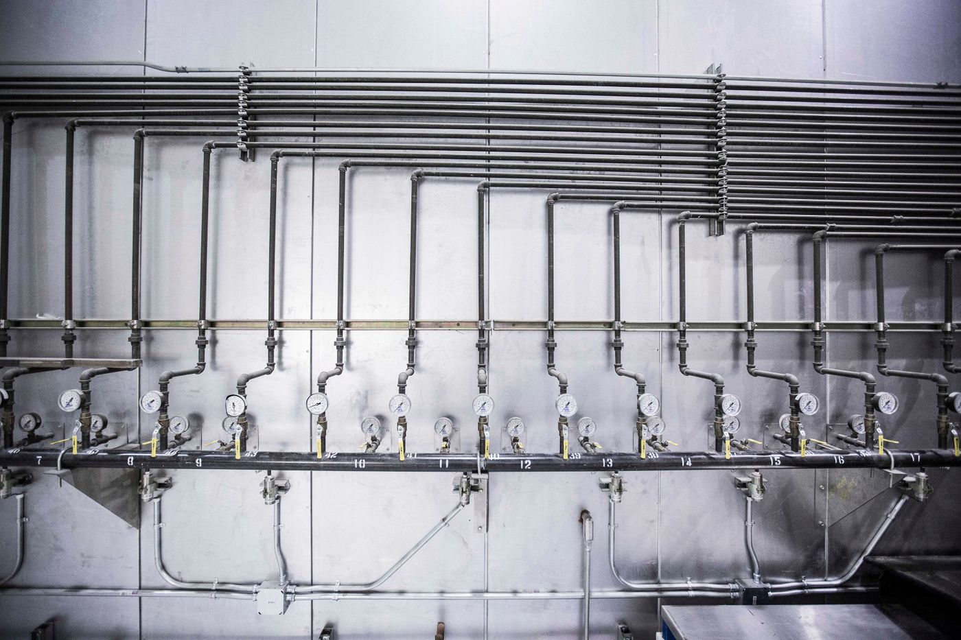 Building mechanical room with steel pipes and pressure gauges